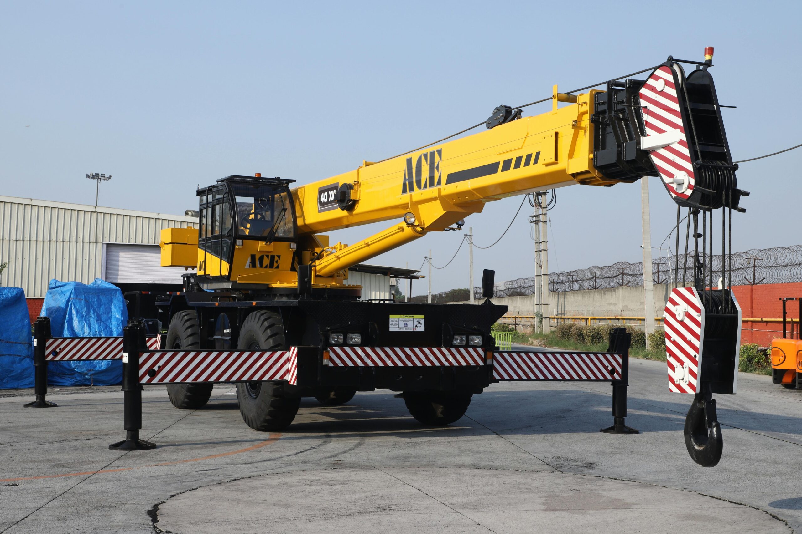Home A 40 ton ACE rough terrain crane parked outdoors in an industrial yard in Faridabad, India.